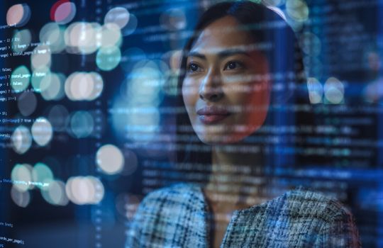 Photo d'une femme devant un écran numérique avec des lignes de code