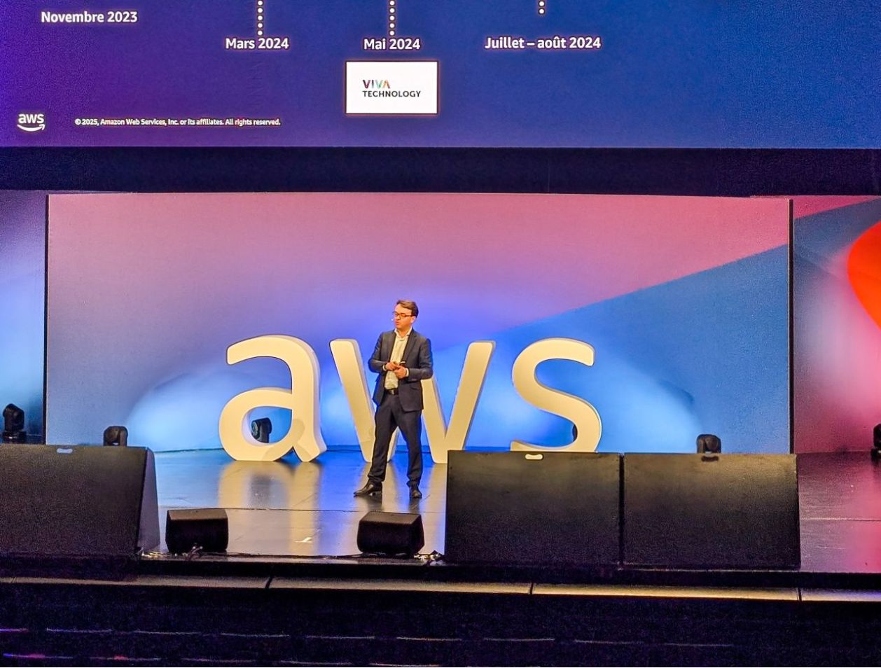 photo d'une conférence de l'aws summit avec un homme sur scène